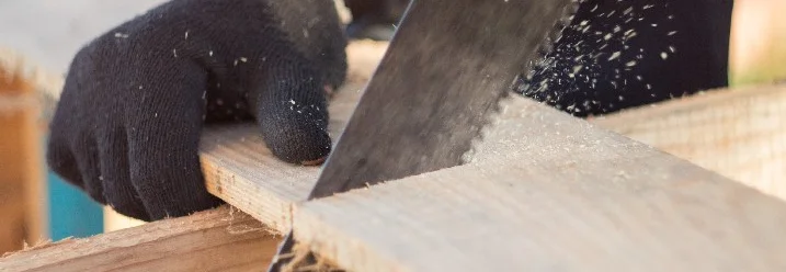 Person sägt Holz mit Säge